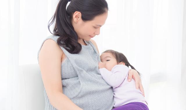Pregnant mum breastfeeding