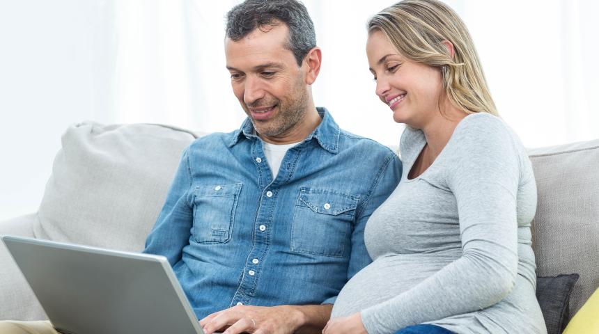 pregnant couple with laptop