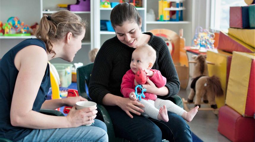 Two mums smile at an ABA group meeting