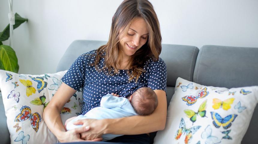 Mum sitting on couch breastfeeding