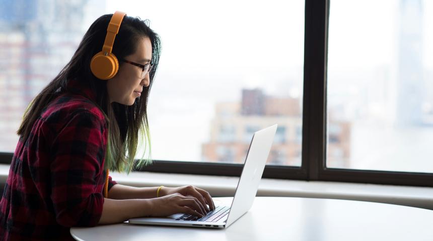 A woman works at a laptop computer