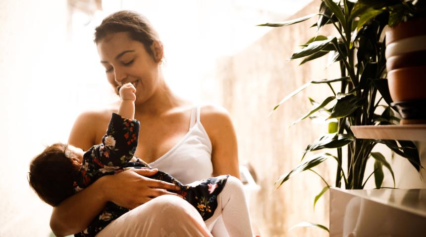 A mother and baby breastfeeding indoors
