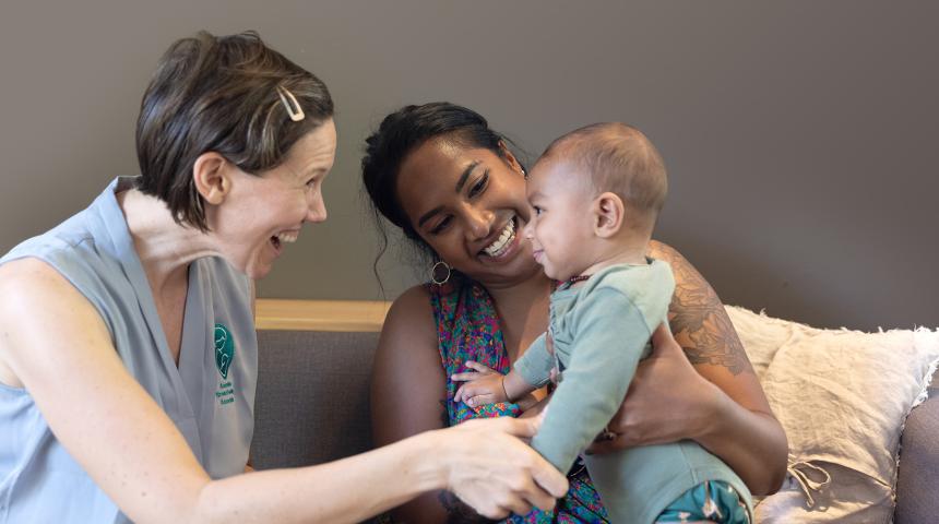 An ABA volunteer smiles with a mum and her baby