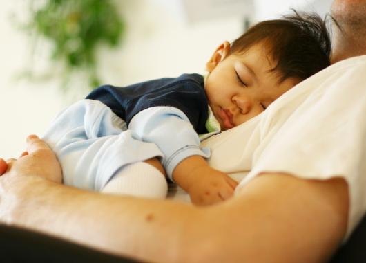 father holding sleeping baby