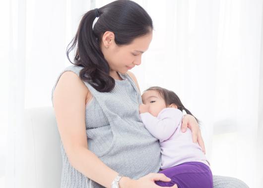 Pregnant mum breastfeeding