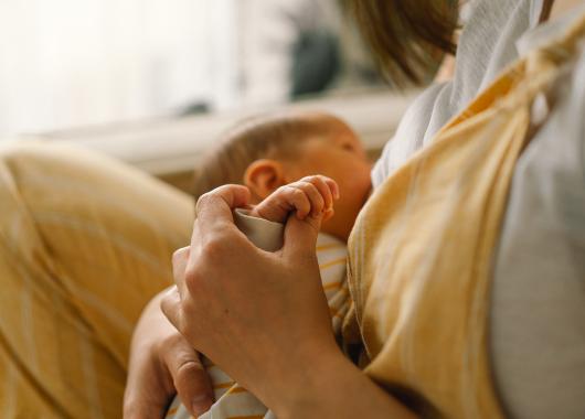 Mother breastfeeds her newborn baby