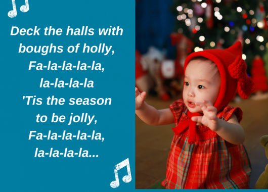Baby dressed in Christmas outfit with Christmas lights in the background