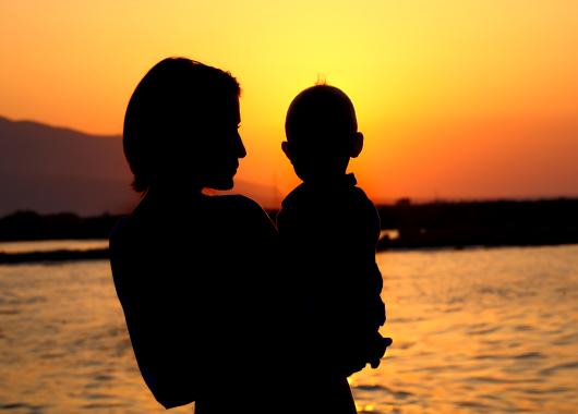 A silhouette of a mother holding her baby