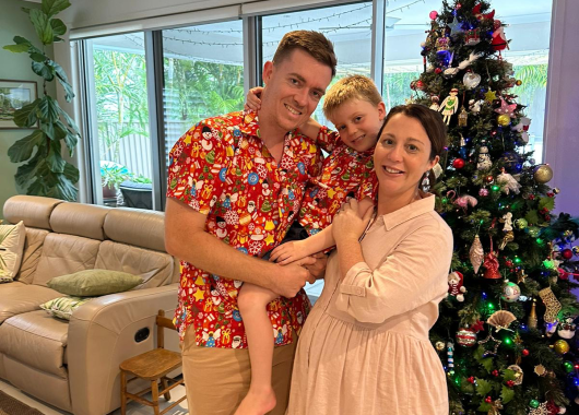 A family standing in front of a Christmas tree.