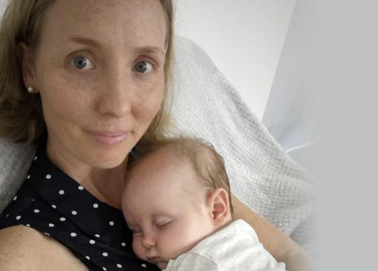 A woman holds her sleeping newborn baby
