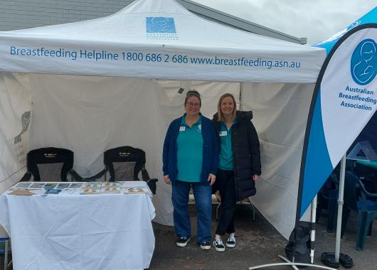 ABA volunteers standing in marquee with information table