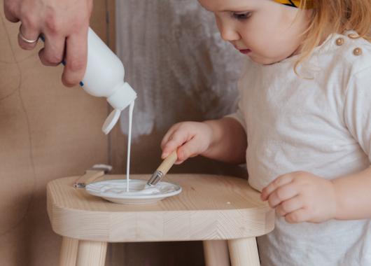 Child with paint brush and glue