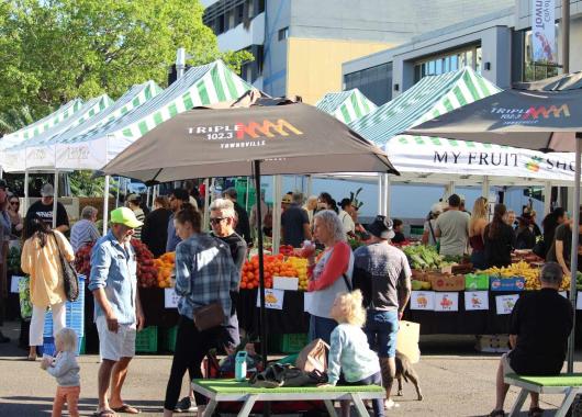 Marquees and people at a market on a sunny day