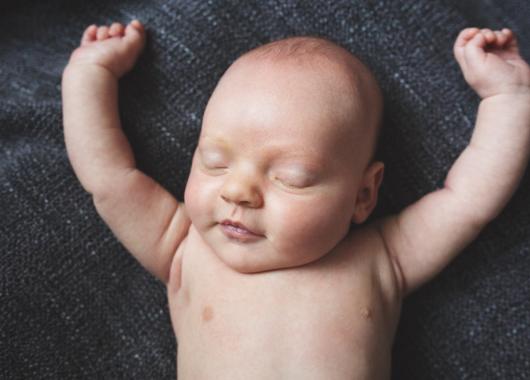 baby asleep with arms in the air