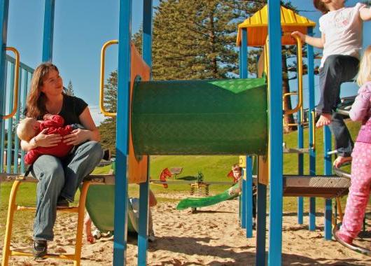Mum breastfeeding baby in park