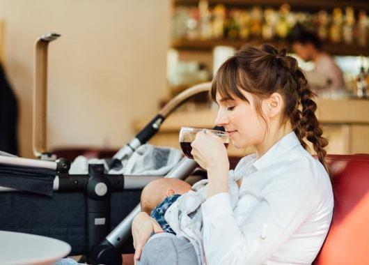 mum breastfeeding and drinking a coffee