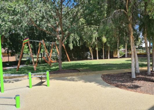 A park with trees and fitness equipment 