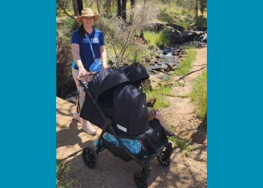 Mother with double stroller walking in bush setting
