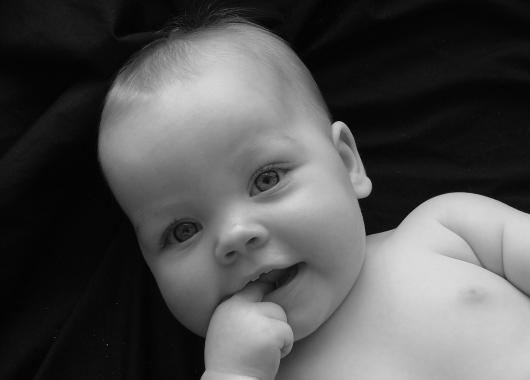 Black and white photo of baby with 2 front teeth