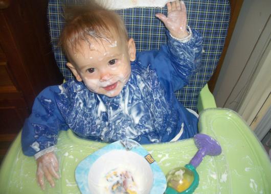 bub in high chair with messy bib