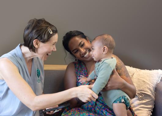 An ABA volunteer smiles with a mum and her baby