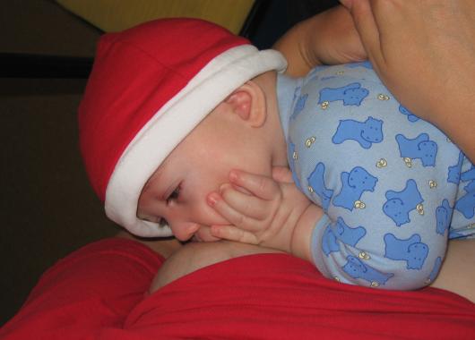 Breastfeeding baby with santa hat