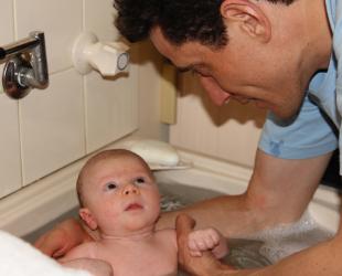 Father bathing baby