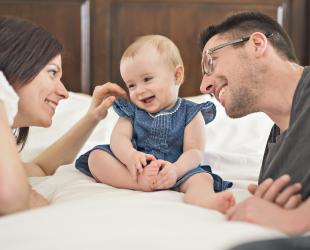 Parents with baby on bed