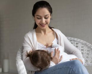 Asian mother feeding older baby