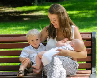 mother feeding on park bench