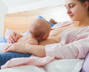 Baby lying on mother feeding