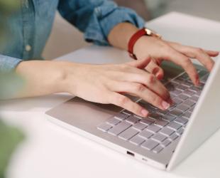 Hands typing on computer