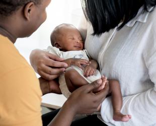 A health professional speaks with mum and baby