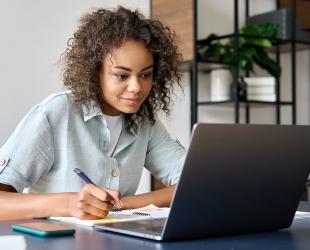 A woman works at her laptop