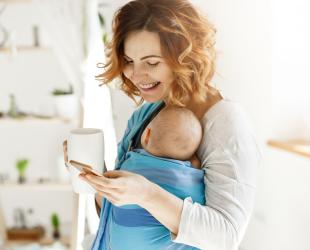 mum carrying baby holding cup