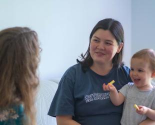 Woman supports a mother and toddler in disaster recovery