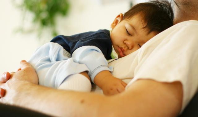 father holding sleeping baby