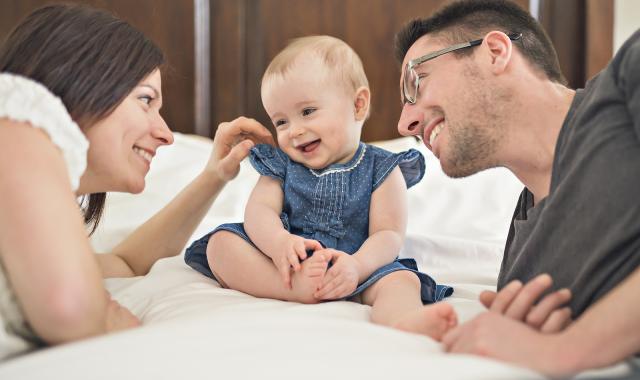 Parents with baby on bed