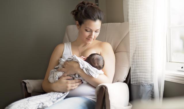 mother breastfeeding in chair