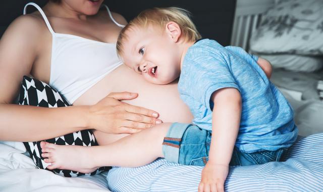 boy listens to mother's tummy