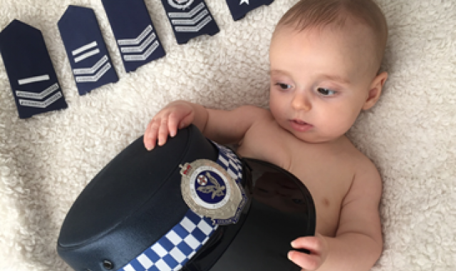 baby hold a police hat