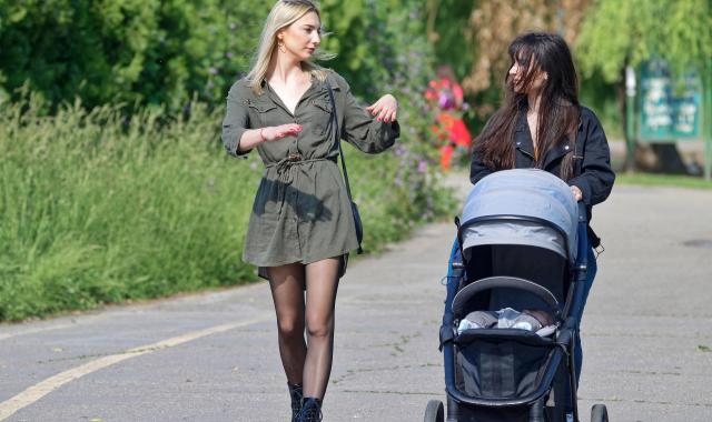 An image of 2 women walking and talking with a baby in a pram
