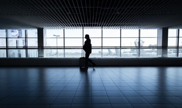 Woman walking at airport with bags