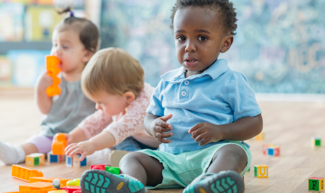 Image of three infant sitting playing with toys