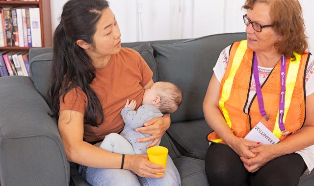 Woman breastfeeding young baby while talking to an emergency responder