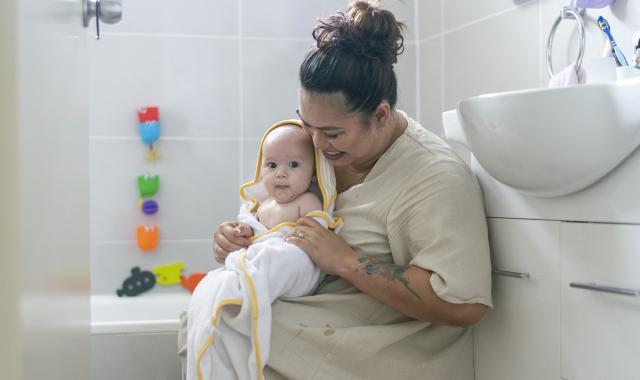 A mother and baby smile after baby's bath