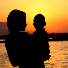 A silhouette of a mother holding her baby
