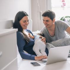 new parents viewing laptop