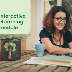 Woman sat at a laptop with a mug in front of her, smiling as she appears to work