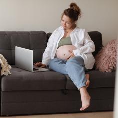 A pregnant woman joins in an event on her laptop